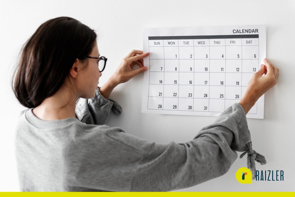 Mulher colocando calendário personalizado na parede